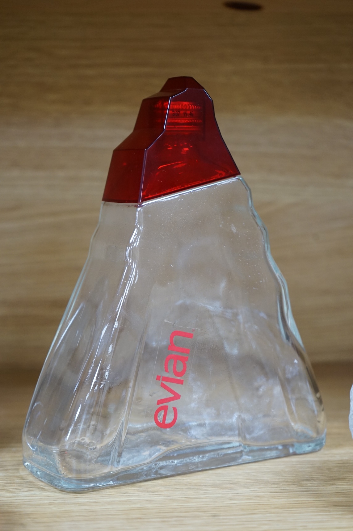 A collection of glassware including a Kosta Boda snowball pot and an Evian advertising water bottle, largest 23cm high